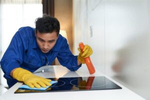 worker-cleaning-stove-surface